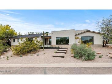 Stylish single-story home featuring a desert landscaped front yard and large windows for ample natural light at 4035 E Mcdonald Dr, Phoenix, AZ 85018