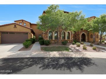 Charming home exterior with a stone facade, mature landscaping, and a two-car garage at 4777 S Fulton Ranch Blvd # 1050, Chandler, AZ 85248