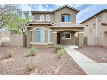 Inviting two-story home featuring a desert-landscaped front yard and covered entryway at 9435 S 33Rd Dr, Laveen, AZ 85339