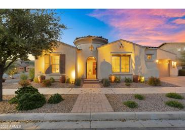 Charming front elevation featuring manicured landscaping, a decorative gate, and warm lighting at 10510 E Sanger Ave, Mesa, AZ 85212