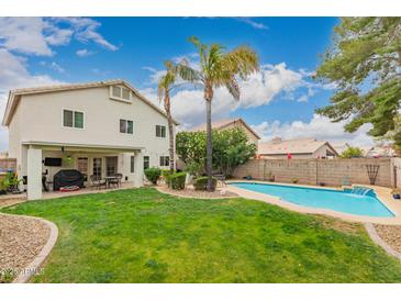 Expansive backyard with a refreshing pool, lush lawn, and outdoor dining area at 15809 N 11Th Ave, Phoenix, AZ 85023