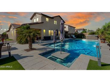 Backyard pool with umbrellas and hot tub at twilight for a relaxing oasis and outdoor entertaining at 18101 N Crestview Ln, Maricopa, AZ 85138