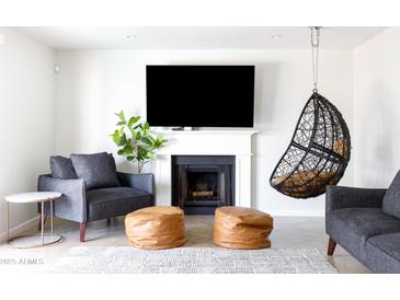 Bright living room features fireplace, mounted television, and hanging chair at 3907 E Marilyn Rd, Phoenix, AZ 85032