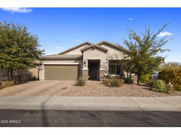 Charming single-story home featuring a well-maintained landscaped front yard, a two car garage and stone accents at 11148 E Tumbleweed Ave, Mesa, AZ 85212