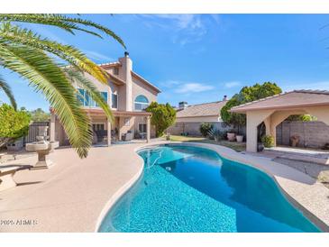 Inviting backyard pool with desert landscaping and a covered patio, perfect for outdoor entertaining at 1313 W Glenmere Dr, Chandler, AZ 85224