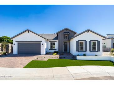 Charming single-story home featuring a well-manicured lawn, brick driveway, and inviting front entry at 14429 N 75Th Dr, Peoria, AZ 85381