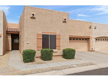 Charming townhome featuring a stucco exterior, one-car garage, well-maintained landscaping, and inviting curb appeal at 1650 S Crismon Rd # 6, Mesa, AZ 85209
