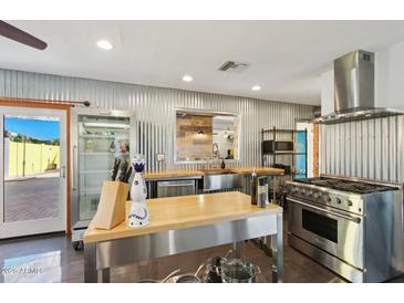 Contemporary kitchen features stainless steel appliances, an island, and a large window over looking the backyard at 2511 E Pinchot Ave, Phoenix, AZ 85016
