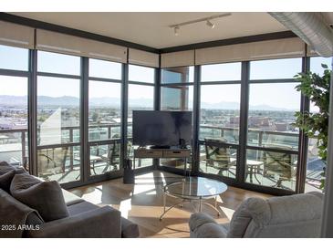 Bright living room with modern finishes, and floor-to-ceiling windows that offer panoramic city views at 310 S 4Th St # 901, Phoenix, AZ 85004