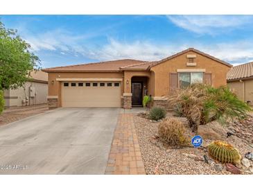 Charming single-story home with desert landscaping, two-car garage and security system at 37161 W Giallo Ln, Maricopa, AZ 85138