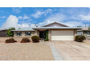 Charming single-story brick home featuring a well-manicured front yard and attached two-car garage at 4138 W Barbara Ave, Phoenix, AZ 85051