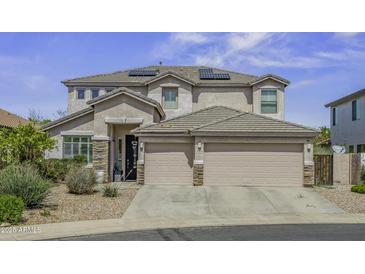 Stunning two-story home featuring a three car garage, neutral paint and solar panels at 43650 W Snow Dr, Maricopa, AZ 85138
