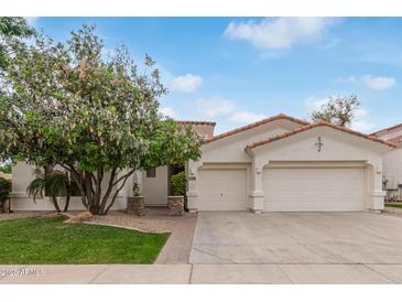 Inviting single-story home featuring a two-car garage, landscaped front yard, and a classic tile roof at 4522 S Wildflower Pl, Chandler, AZ 85248