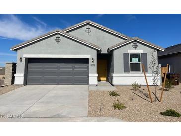 Charming single-story home with gray exterior, well-manicured landscaping, and a two-car garage at 582 W Freedom St, Florence, AZ 85132