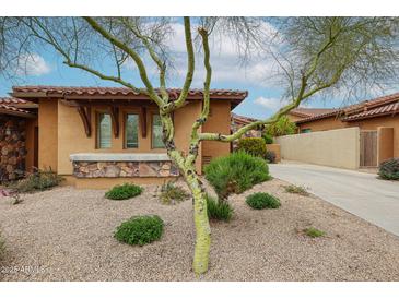 Inviting front yard featuring desert landscaping and a charming porch with stone accents on a sunny day at 7216 E Aurora --, Scottsdale, AZ 85266