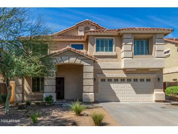Charming two-story home featuring a stone-accented entry, a two-car garage, and a well-maintained front yard at 7622 S 69Th Dr, Laveen, AZ 85339