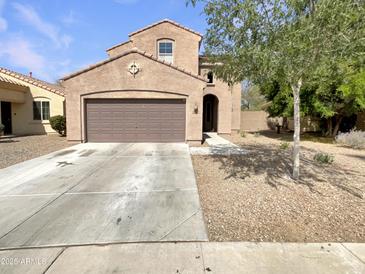 Tan two-story home with a two-car garage and landscaped front yard with a concrete driveway at 7924 S 70Th Ln, Laveen, AZ 85339