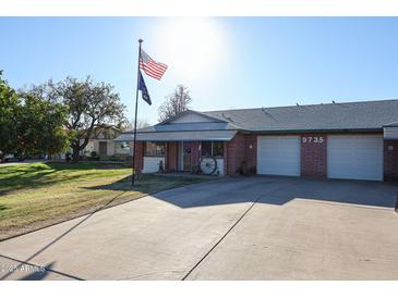 Charming single-story home with a well-manicured lawn, American flag, and two-car garage at 9735 W Ironwood Dr # A, Peoria, AZ 85345