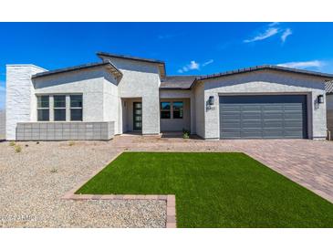 Modern home exterior with a gray garage door and landscaped front yard at 14407 N 75Th Dr, Peoria, AZ 85381