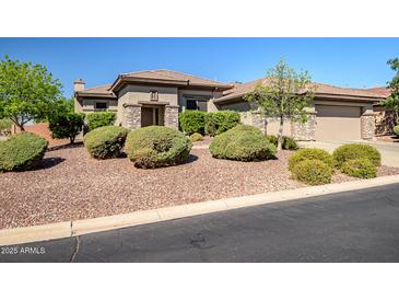 Charming home featuring desert landscaping, a quaint front entry and a neutral color palette at 1557 W Laurel Greens Ct, Anthem, AZ 85086