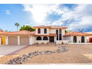 Charming two-story home with red tile roof, two-car garage and desert landscaping at 17012 N 57Th St, Scottsdale, AZ 85254