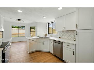 Bright kitchen featuring white cabinets, stainless appliances, and views to backyard at 1918 E Anchor Dr, Gilbert, AZ 85234