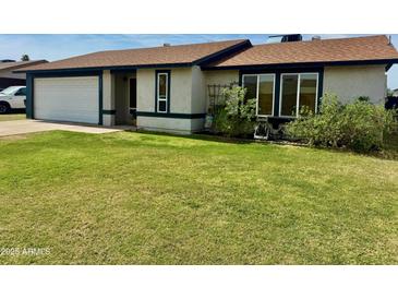 Charming single-story home featuring a well-maintained lawn and a two-car garage at 2329 E Juanita Ave, Mesa, AZ 85204