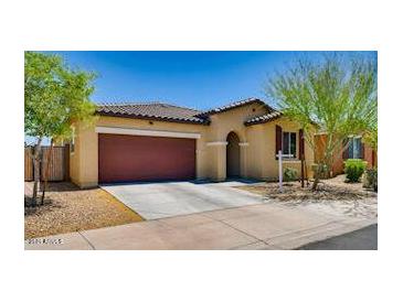 Charming single-story home featuring a tile roof, two-car garage, and inviting front yard landscaping at 6413 S 47Th Dr, Laveen, AZ 85339