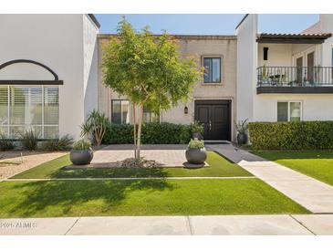 Inviting front entrance featuring a manicured lawn and tasteful landscaping that enhances the home's curb appeal at 7694 E Minnezona Ave, Scottsdale, AZ 85251