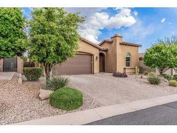 Lovely home showcases mature trees, desert landscaping, paver driveway, and attached two-car garage at 10713 N 124Th Pl, Scottsdale, AZ 85259