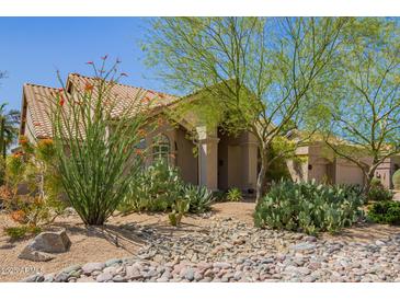 Inviting single-story home with well-manicured desert landscaping and covered entry at 12749 E Poinsettia Dr, Scottsdale, AZ 85259