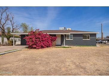Charming single-story home featuring a dark gray brick exterior and a well-manicured front yard at 3222 W Marshall Ave, Phoenix, AZ 85017
