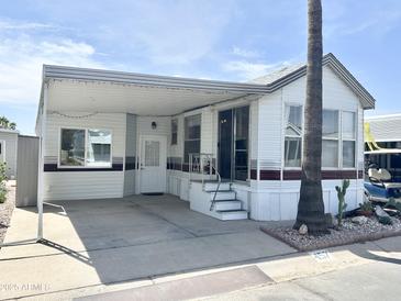 Charming manufactured home featuring a covered carport and well-maintained landscaping at 457 S Jaspar Dr, Apache Junction, AZ 85119