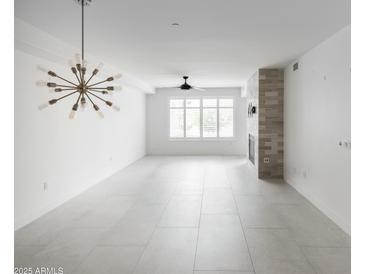 Bright living room featuring a modern light fixture, fan, tile flooring and a stylish fireplace at 4803 N Woodmere Fairway -- # 1003, Scottsdale, AZ 85251