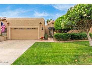 Charming single-story home with a well-manicured lawn and a two-car garage, with lovely trees at 9442 N 106Th Pl, Scottsdale, AZ 85258