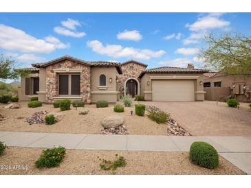 Charming home featuring a stone facade, a paver driveway, and desert landscaping in a well-maintained front yard at 1608 W Calle De Pompas --, Phoenix, AZ 85085
