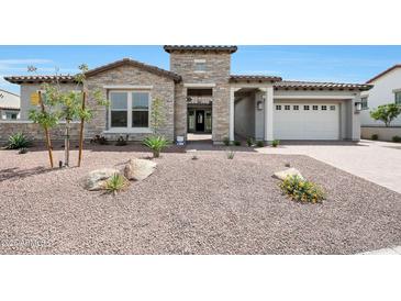 Beautiful single-story home showcasing a stone facade, tile roof, and well-maintained desert landscaping at 20775 W Rattler Rd, Buckeye, AZ 85396