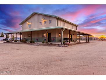 Stunning two-story home featuring wraparound porch and a colorful sunset backdrop at 29756 N Varnum Rd, San Tan Valley, AZ 85143
