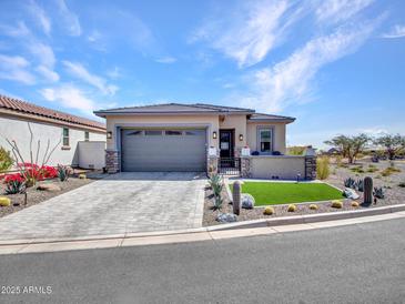 Charming single-story home featuring a paver driveway, stone accents, and desert landscaping at 5581 N 206Th Ave, Buckeye, AZ 85396