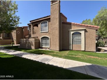 Charming condo exterior with a red tile roof, stucco walls, and a well-maintained lawn at 6945 E Cochise Rd # 108, Paradise Valley, AZ 85253