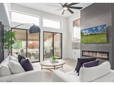 Bright living room with modern fireplace, large windows, and access to outdoor seating at 8989 N Gainey Center Dr # 231, Scottsdale, AZ 85258
