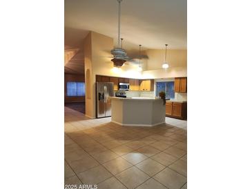 Open-concept kitchen with a breakfast bar, stainless steel appliances, and tile floors at 11233 W Olive Dr, Avondale, AZ 85392