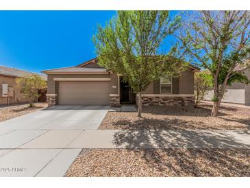 Charming home featuring a two-car garage, easy-care desert landscaping, and stone accents at 15573 W Laurel Ln, Surprise, AZ 85379