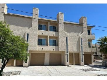 View of condo building with attached garages, stucco facade, and low maintenance landscaping at 225 N Pomeroy -- # 16, Mesa, AZ 85201