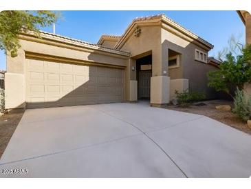Charming single-story home featuring an attached two-car garage, neutral stucco, and a concrete driveway at 4031 E Barwick Dr, Cave Creek, AZ 85331