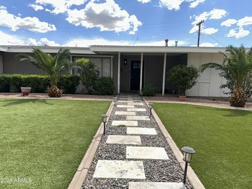 Charming home featuring a lovely landscaped front yard and inviting walkway at 6207 W Orange Dr, Glendale, AZ 85301