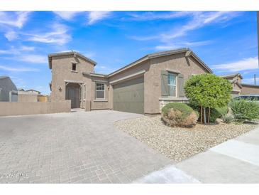 Charming single-story home features desert landscaping, paver driveway, and a two-car garage at 1900 N 140Th Dr, Goodyear, AZ 85395