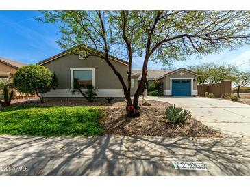 Charming single-story home with a well-manicured front yard and vibrant desert landscaping under a clear blue sky at 23063 W Loma Linda Blvd, Buckeye, AZ 85326