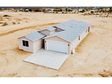 New home with a modern design, neutral colors, a two-car garage, and a concrete driveway at 25745 W Peak View Rd, Wittmann, AZ 85361