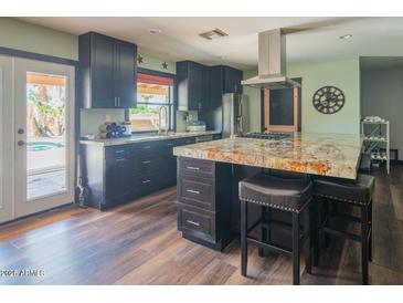 Modern kitchen with dark wood cabinets, stainless steel appliances, and granite countertops at 6428 E Shea Blvd, Scottsdale, AZ 85254